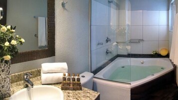 Un bagno con una vasca da bagno ampia, un lavandino e uno spazio doccia.