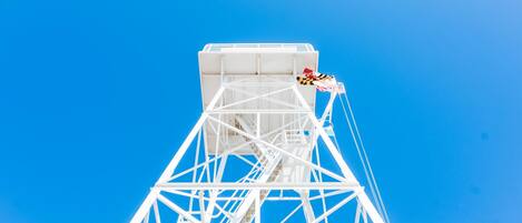 Une structure en métal blanc, en forme de tour, avec un escalier menant au sommet.