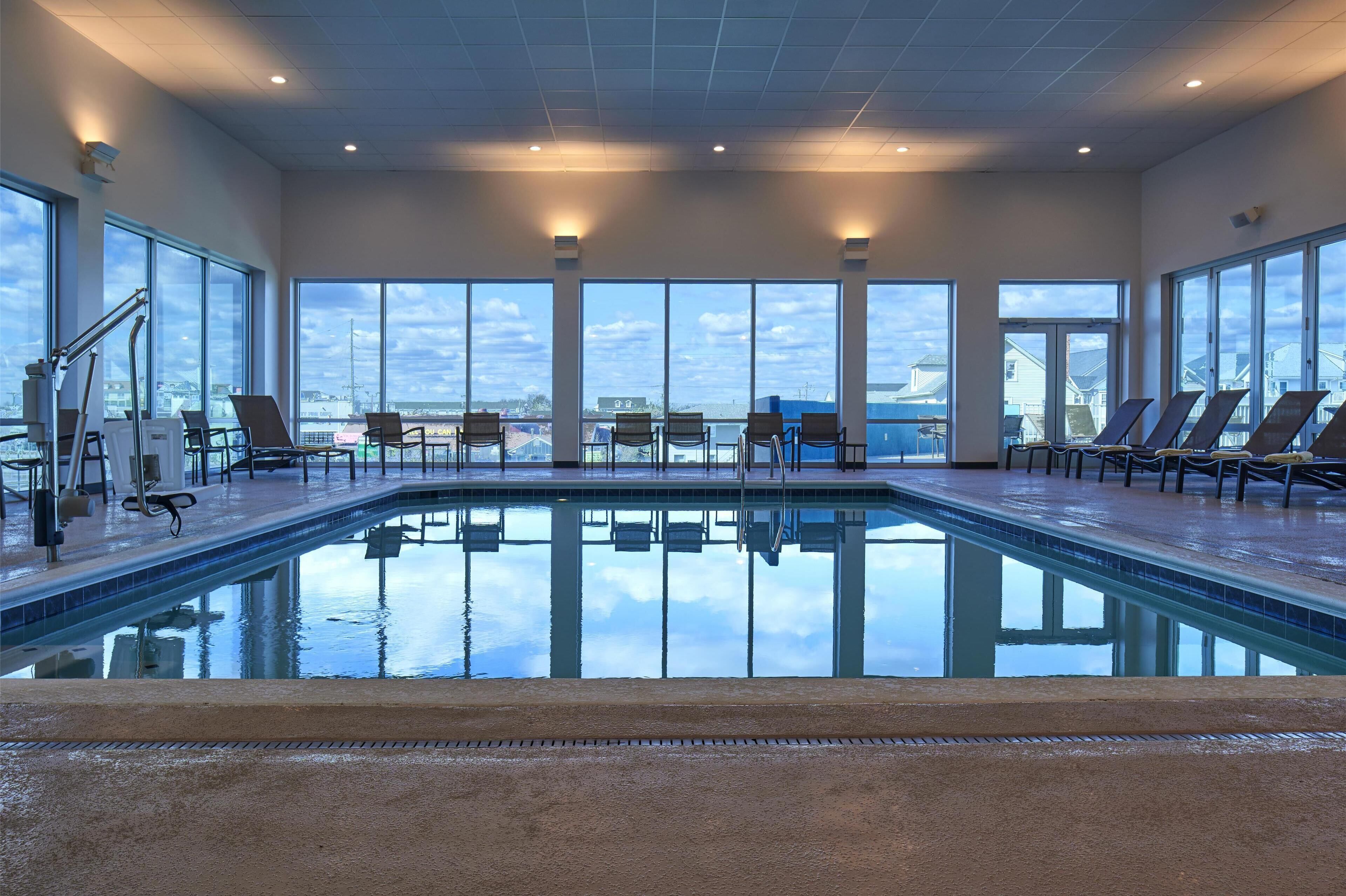 Une piscine avec des chaises longues et une vue sur la ville.