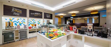 A modern breakfast bar with a variety of food options and a coffee station.