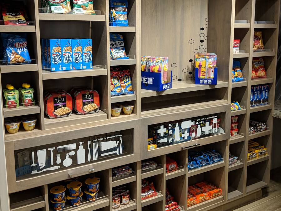 A snack display in a store with various packaged snacks and personal care items.