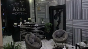 Una zona de recepción con un mostrador negro, sillas con estampado y una decoración interior moderna.