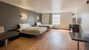 A hotel room with two beds, a TV, a desk, and a window with a view of the outdoors. - Studio 6 Mccarran, NV - Sparks - Tahoe - Reno Industrial Center (Sparks)