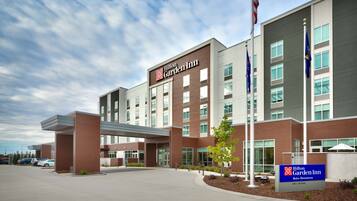 A Hilton Garden Inn with a modern design, featuring a large parking lot and a well-maintained entrance area.