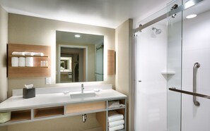 A modern bathroom with a large mirror, a sink, and a glass-enclosed shower. - Hilton Garden Inn Boise Downtown (Boise)