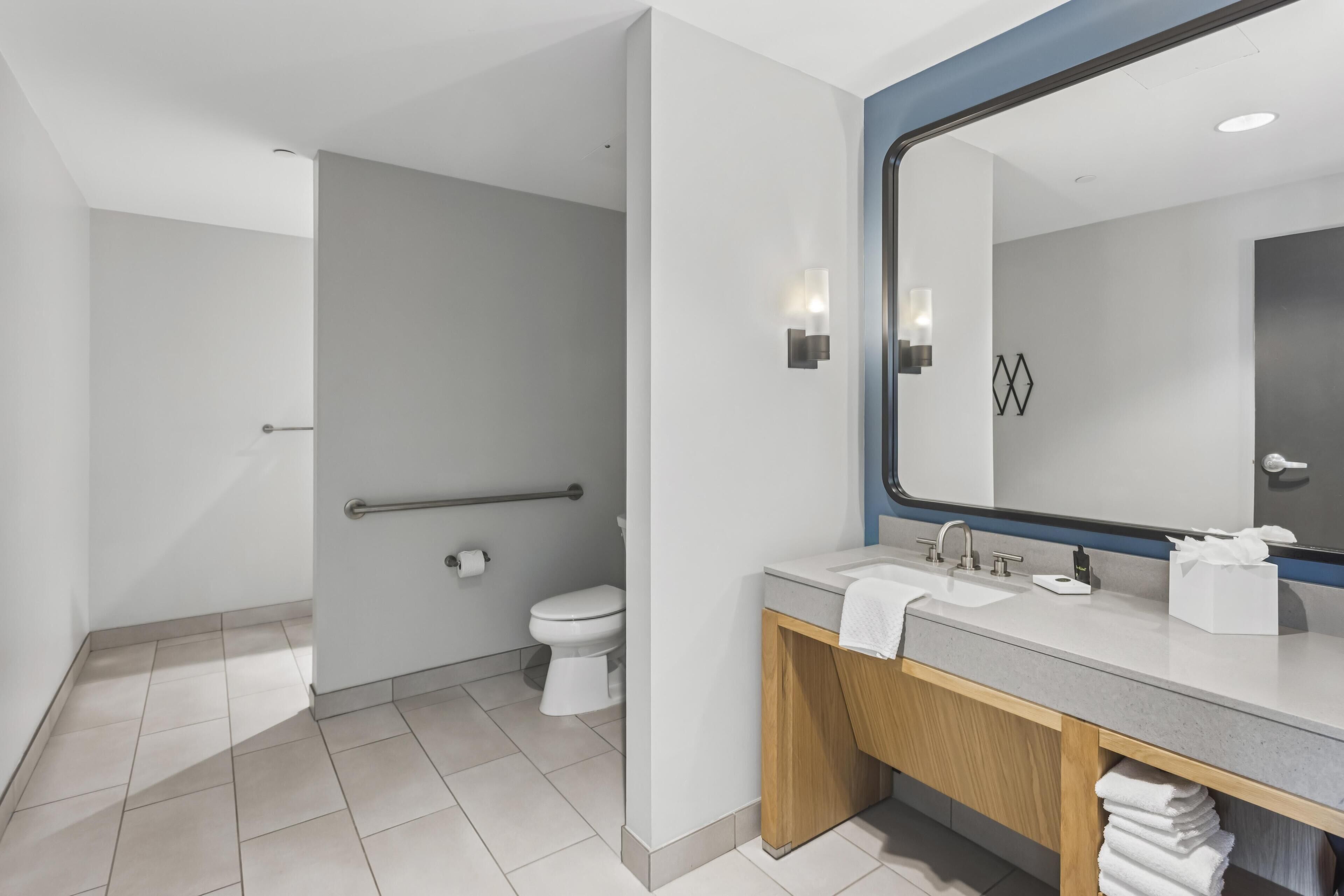 Une salle de bain moderne avec des toilettes, un lavabo et un miroir.