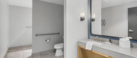 Et moderne badeværelse med toilet, vask og spejl.