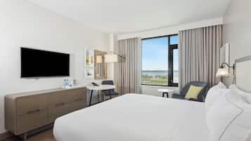 A hotel room with a large bed, a flat-screen TV, a desk, and a chair.