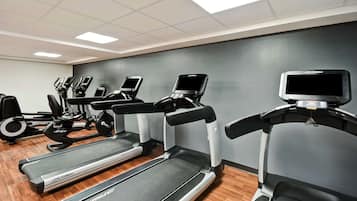 A gym with treadmills, ellipticals, and stationary bikes.