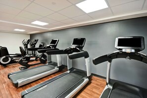 Ein Fitnessraum mit Laufbändern, Crosstrainern und Ergometer.