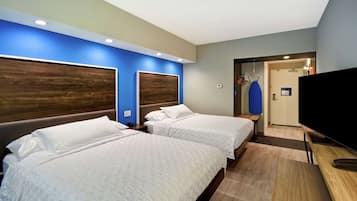 A hotel room with two beds, a TV, and a shower area.