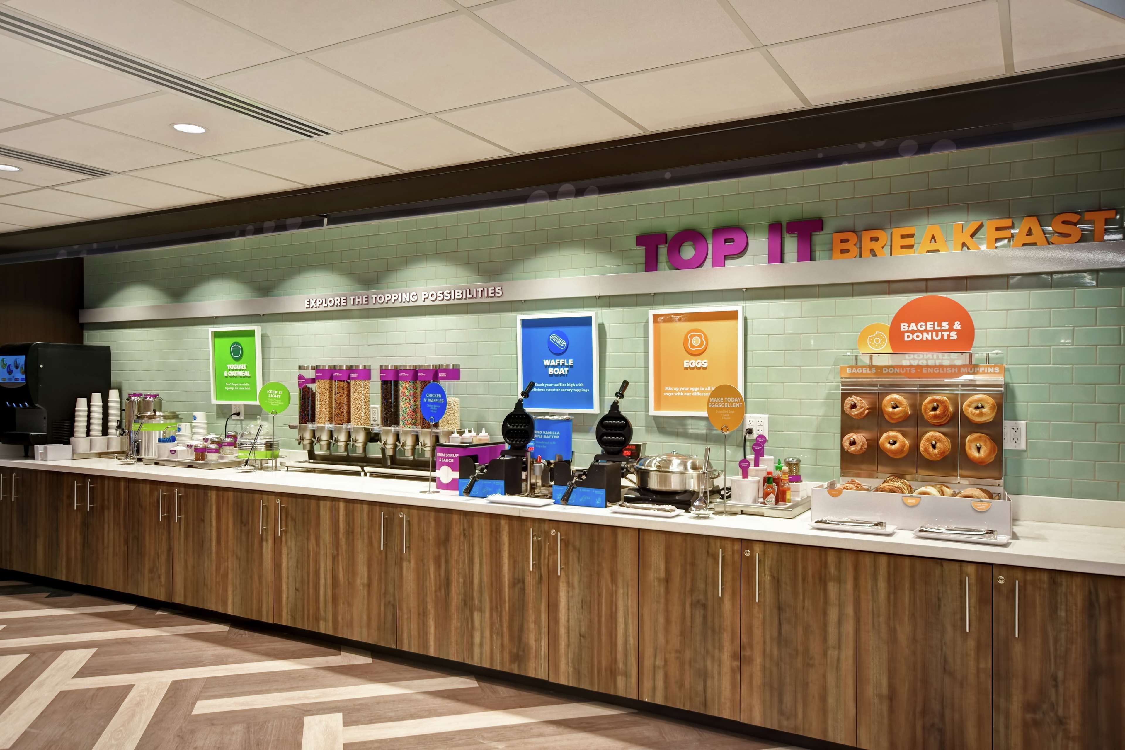 A breakfast counter with various food options and a sign that reads "TOP IT BREAKFAST".