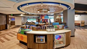 Un kiosque en libre-service équipé d’une machine à café, d’un présentoir réfrigéré et proposant divers produits alimentaires.