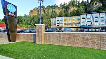 Un hotel con el letrero Hilton, un muro de ladrillo y un edificio con múltiples ventanas al fondo.