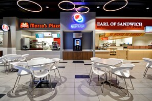 Ein Food-Court mit Sitzgelegenheiten und einer Pepsi-Fontäne.