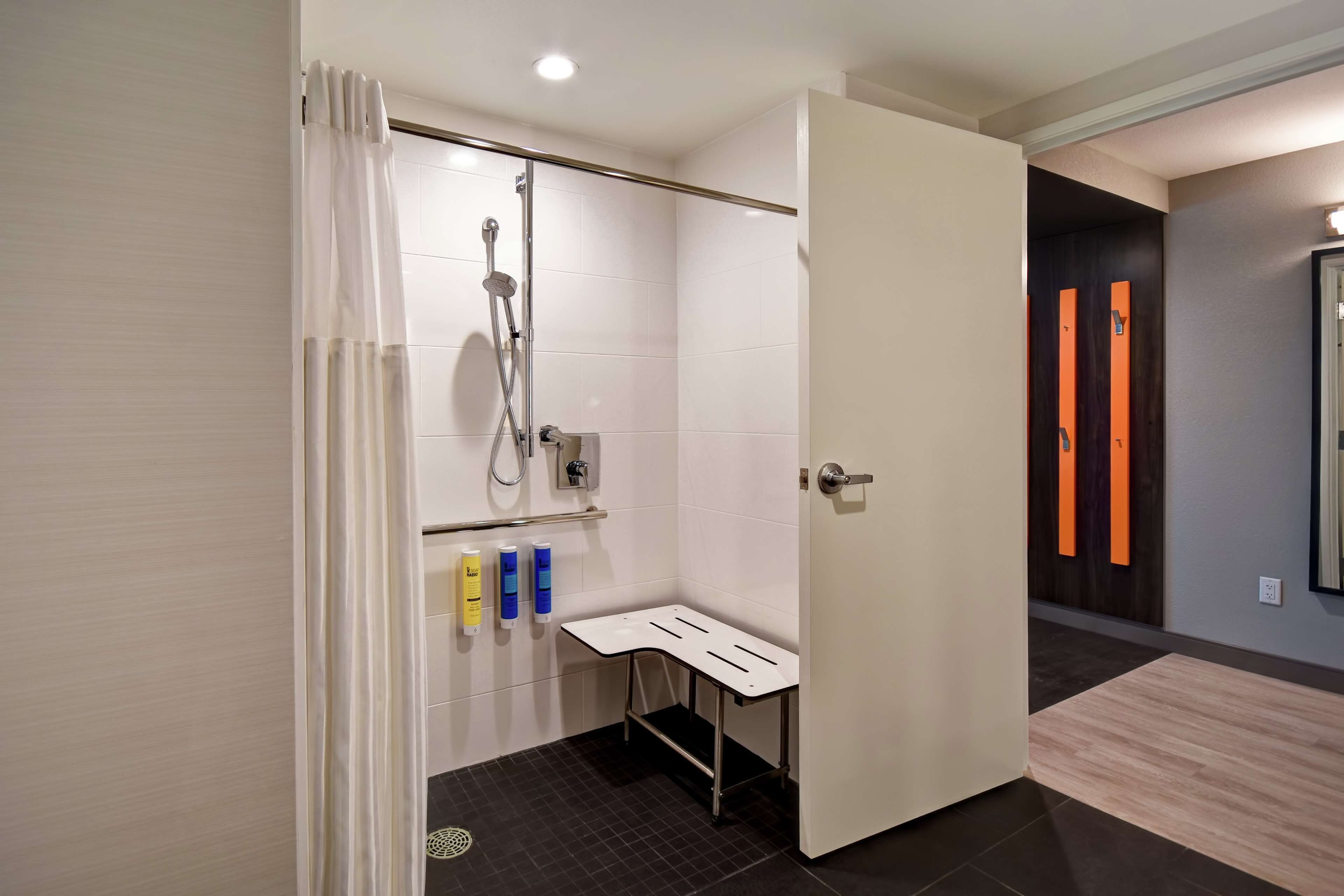 A modern bathroom with a shower, toilet, and sink.