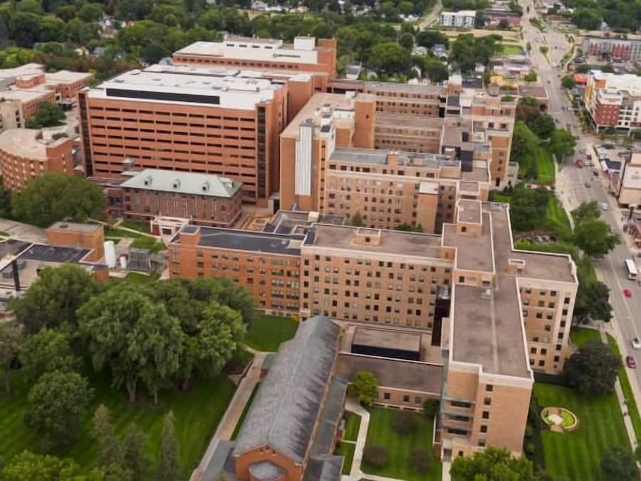 Oversigtsbillede af et campus med flere bygninger, herunder en stor murstensbygning med fladt tag og en mindre bygning med en kuppel.