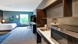 A modern hotel room with a bed, desk, and kitchenette. - Home2 Suites by Hilton Rochester Mayo Clinic Area (Rochester)