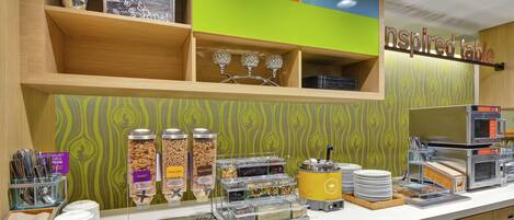 A breakfast bar with various food dispensers, a microwave, and a coffee machine.