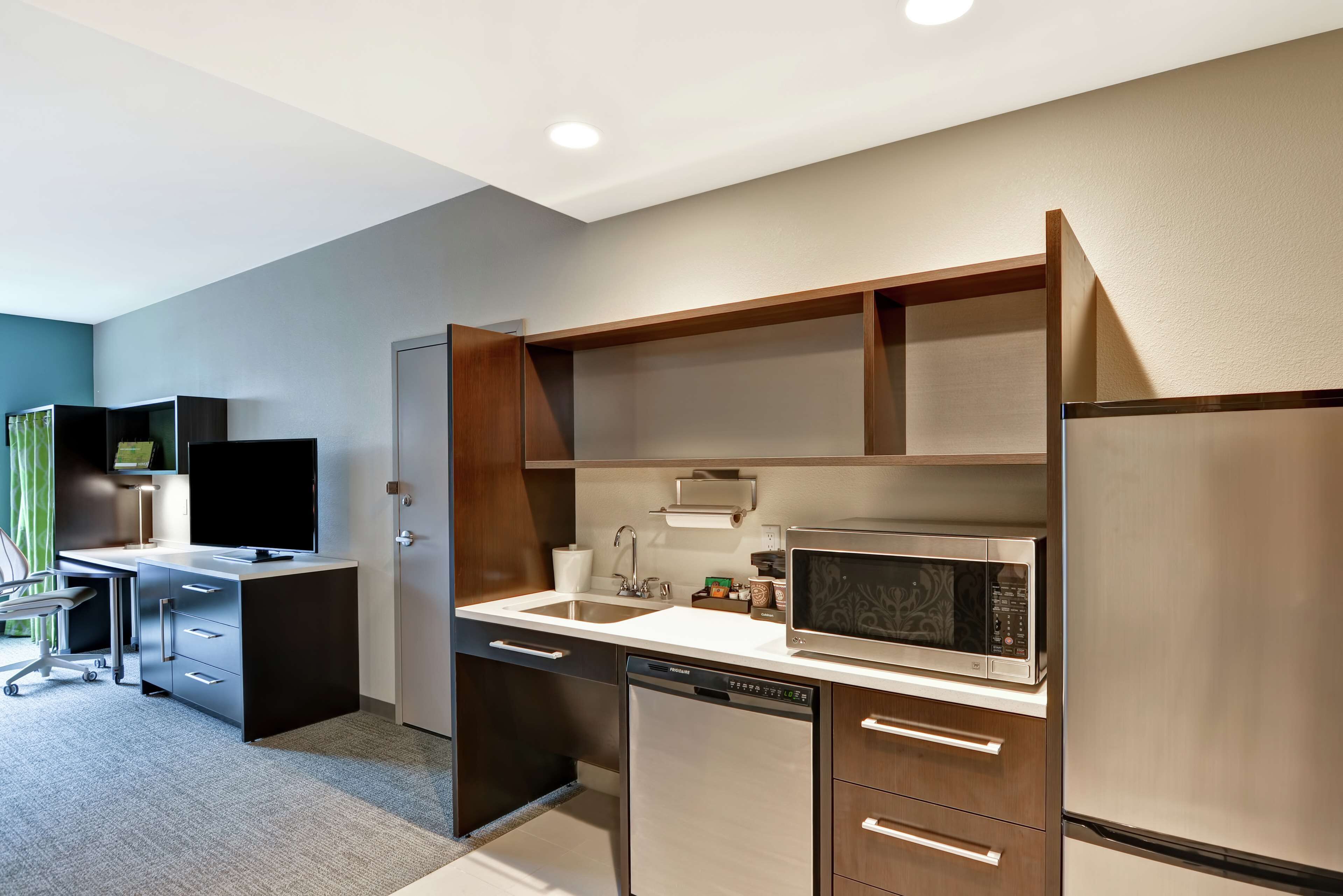 A modern kitchen with a built-in microwave, dishwasher, and refrigerator.