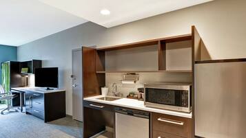 A modern kitchen with a built-in microwave, dishwasher, and refrigerator.