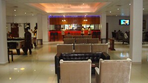 Un hall d’hôtel doté d’une table de billard, d’un espace salon et d’un bar.