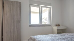 A bedroom with a bed, a wardrobe, a window, and a desk. - Apartments Villa Franci (Pag)