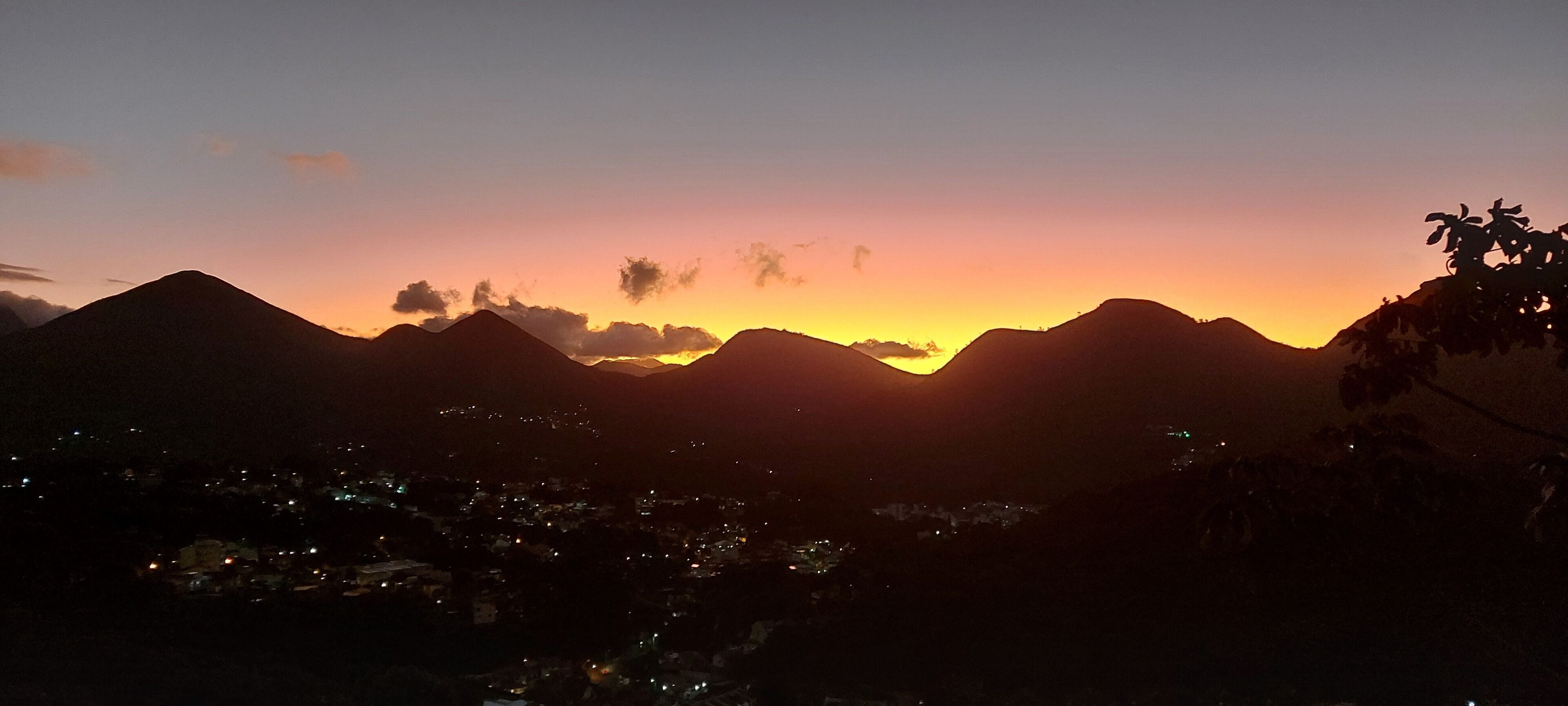 A mountain range silhouette against a sunset sky.