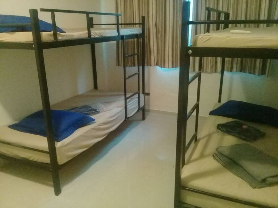 Quarto com beliche, cortina e janela.