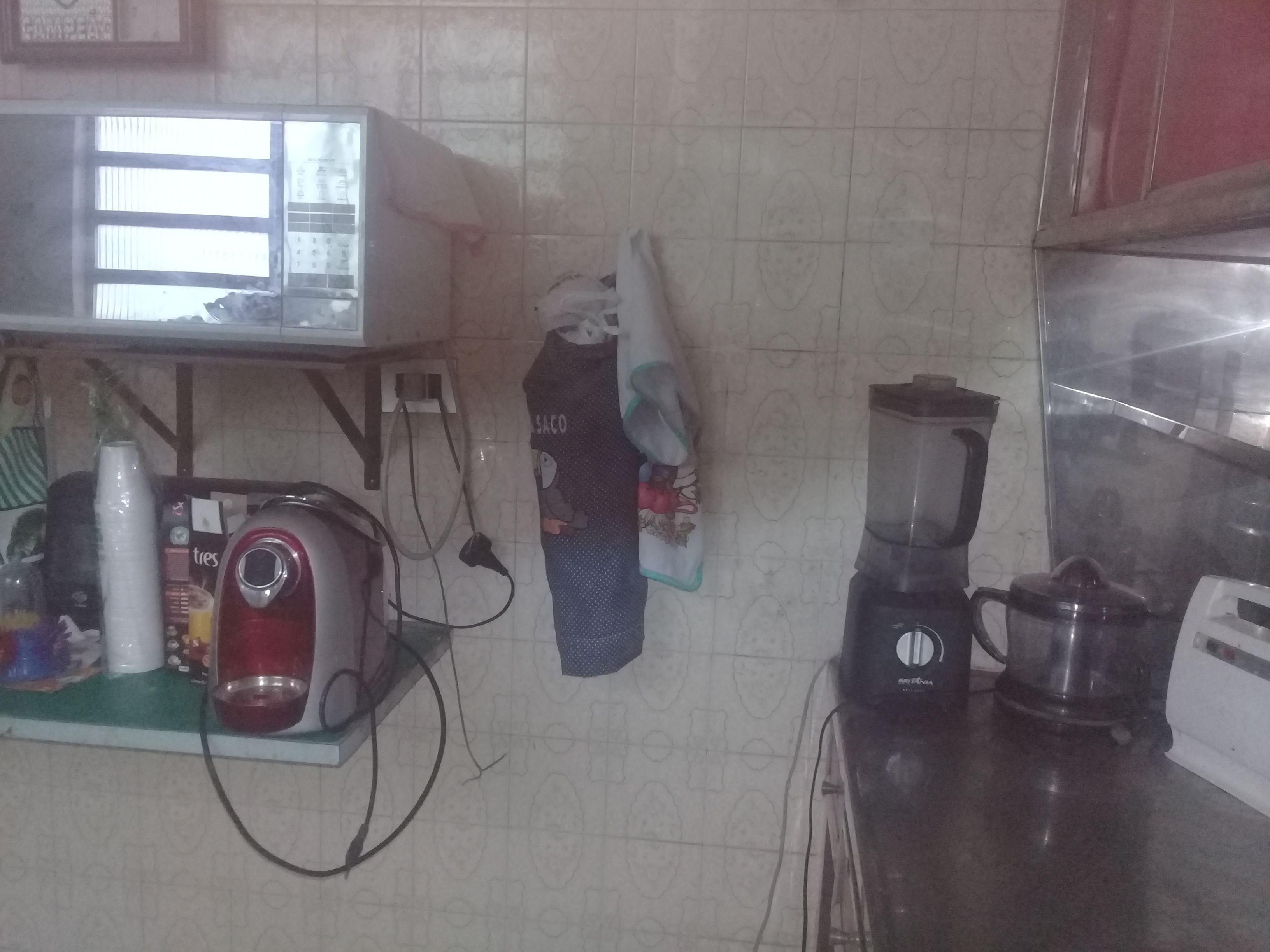 A kitchen with a microwave, blender, and various kitchen items on the counter.