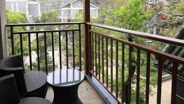 Un balcón con vistas a un pueblo tradicional y montañas.