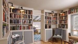 A cozy reading room with bookshelves, a wooden floor, and a comfortable chair. - The Deers Head Inn (Elizabethtown)