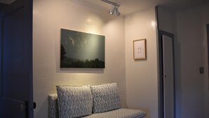 A hallway with a sofa, a painting, and a door. - The Deers Head Inn (Elizabethtown)