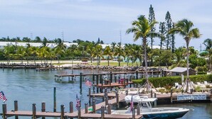 A marina with docked boats, a wooden pier, and a sign for 'Luxury Vacation Homes for rent'. - 🌸Home(#5) “AFTER DUNE🍹DELIGHT”(-approximately 50 ft from Private beach entrance)🌸 (Marathon)