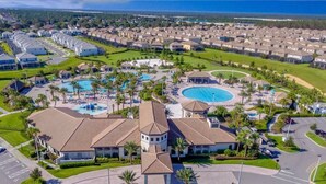 A resort with multiple swimming pools, a central building with a tower, and a residential area with houses. - Private Pool-Upgraded Interior-Poolside Bar (Davenport)