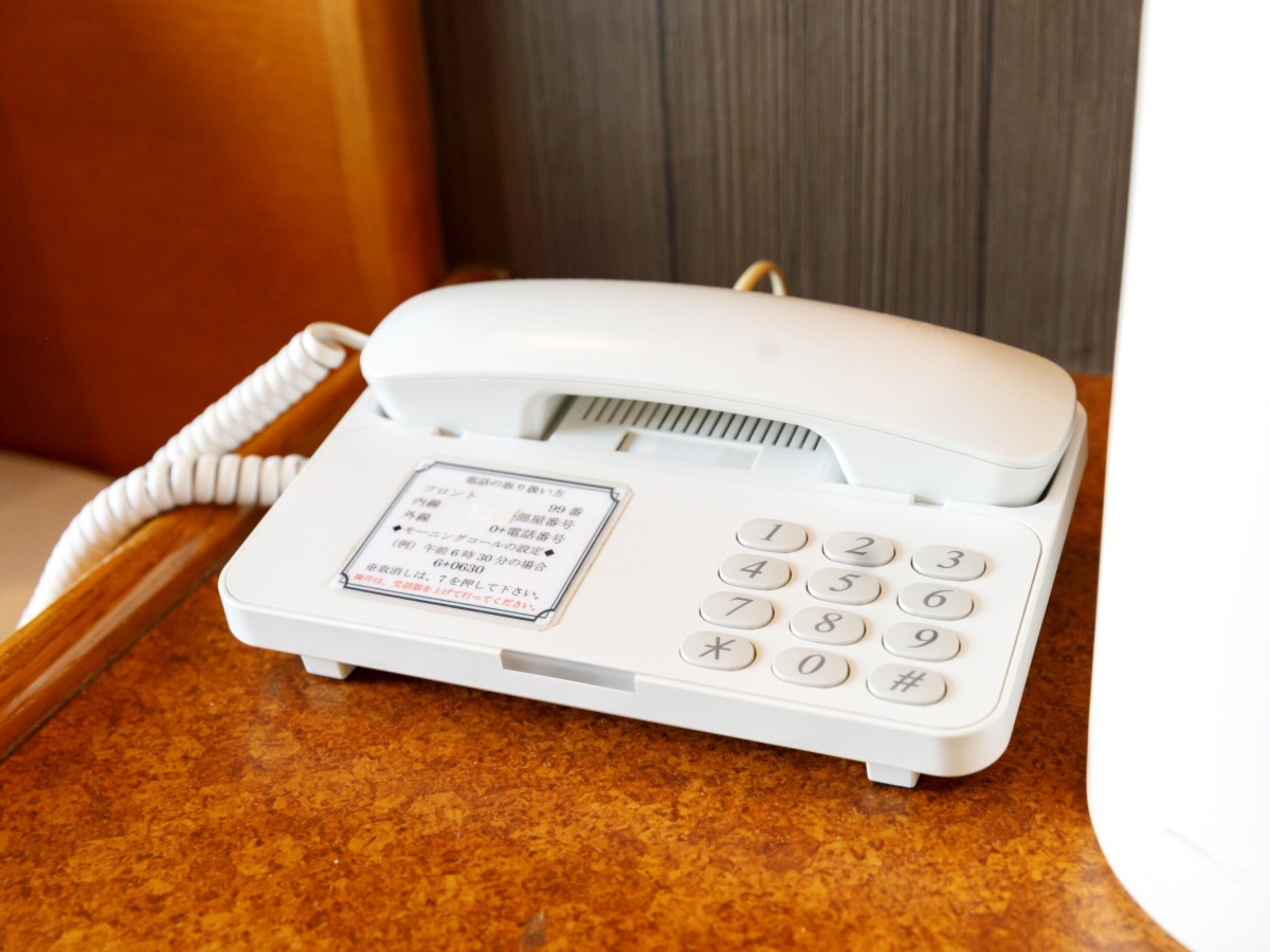 Um telefone branco com teclado e uma etiqueta na frente.