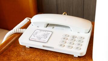 Um telefone branco com teclado e uma etiqueta na frente.
