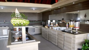 Una cocina moderna con una isla central, una escultura decorativa de sandía y diversos electrodomésticos.