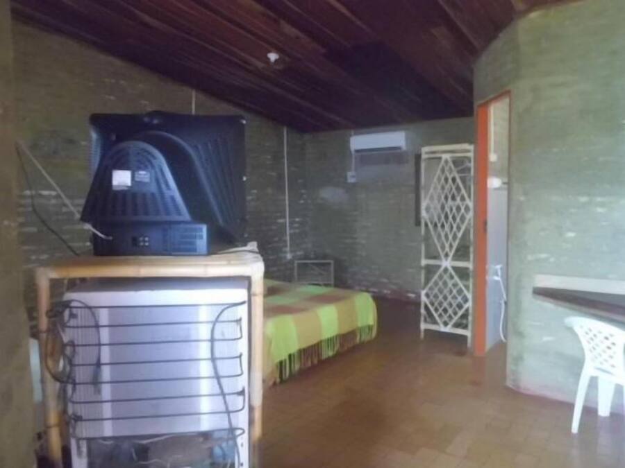 A room with a bed, a small table, a chair, and a heater.