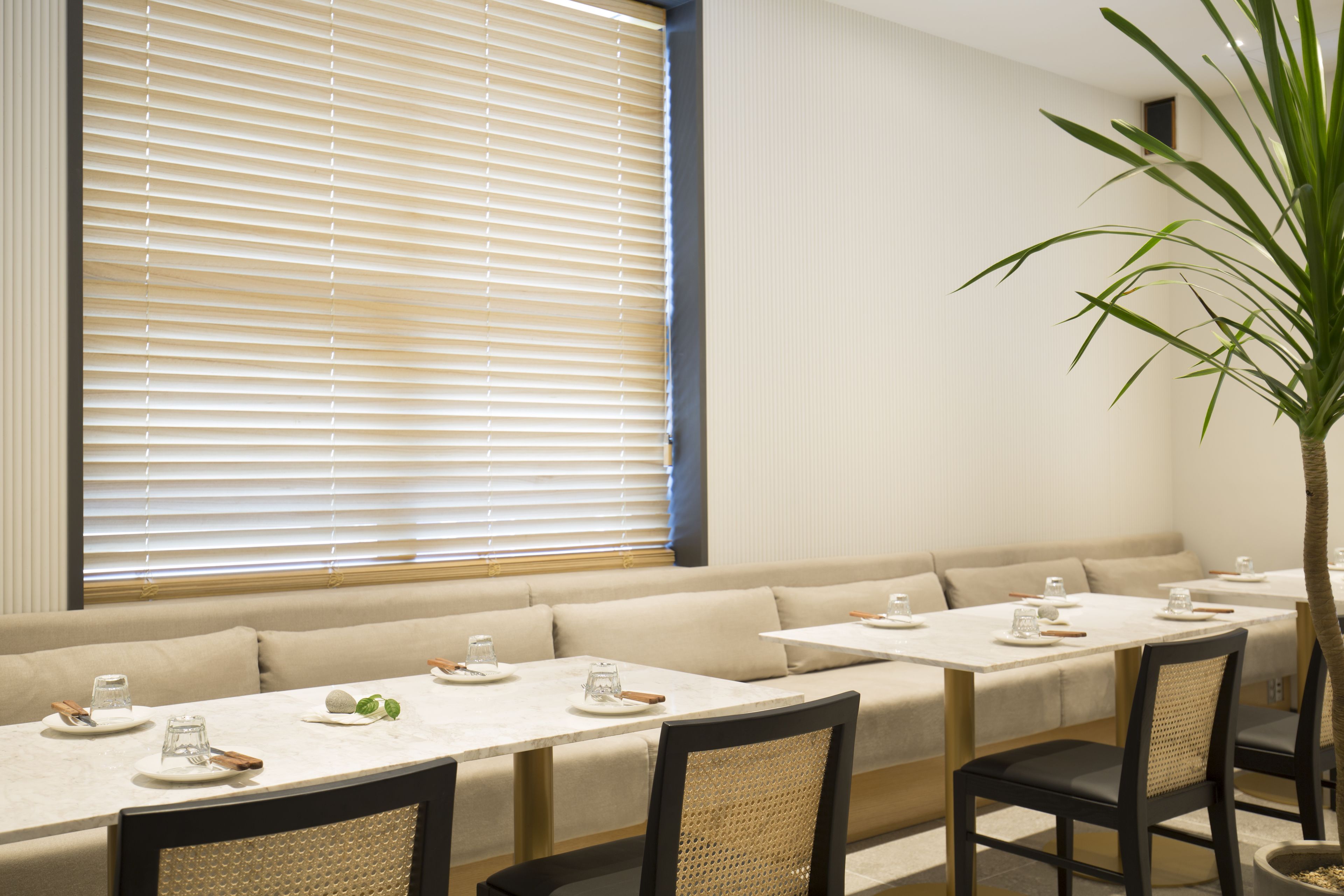 A dining area with a long table, multiple chairs, and a sofa.