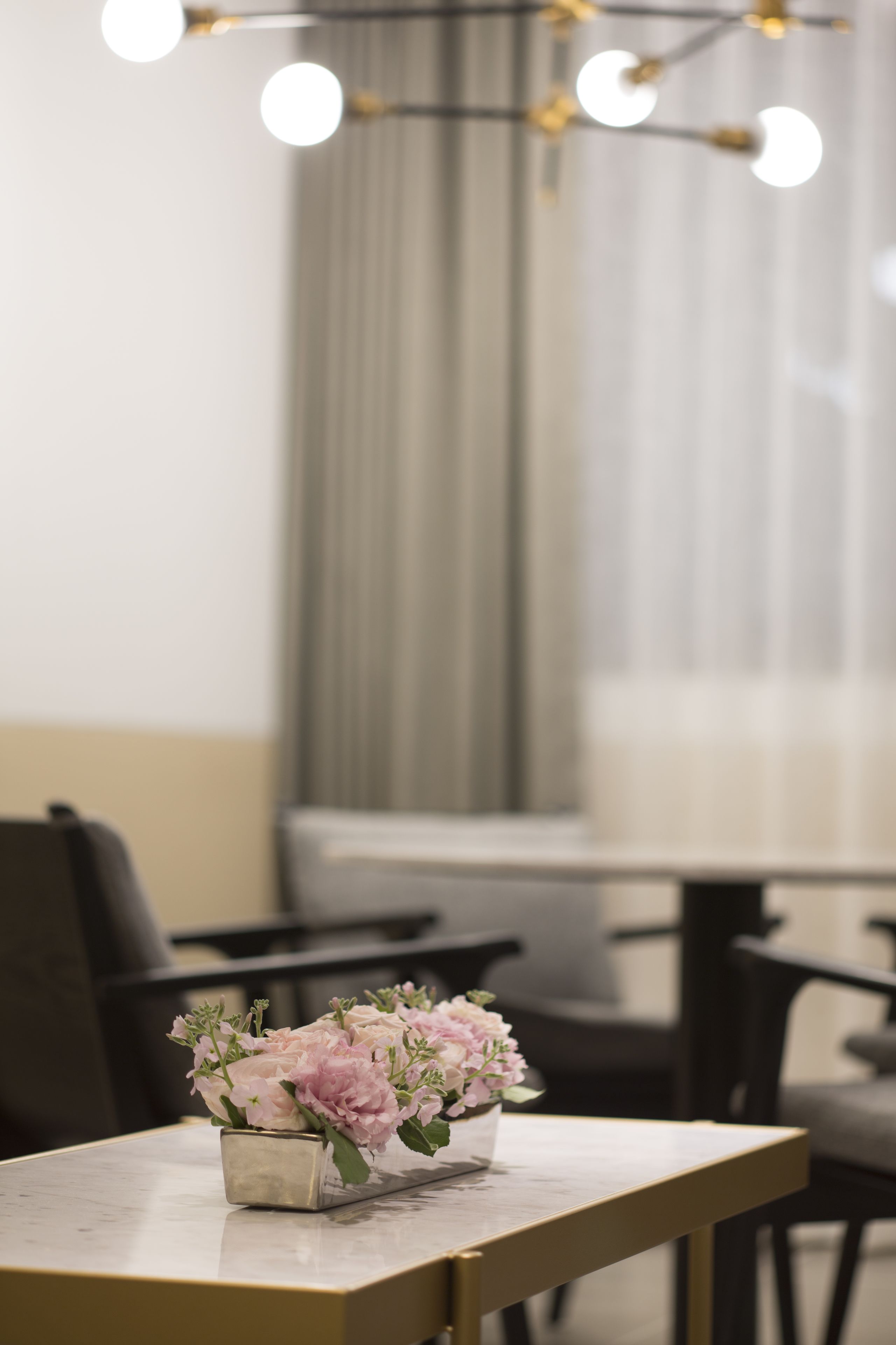A table with a vase of flowers in a modern setting.