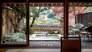 A traditional Japanese room with tatami flooring, a wooden ceiling, and a view of a garden with a hot spring. - Wakamatsu HakoneYugawara (Yugawara)