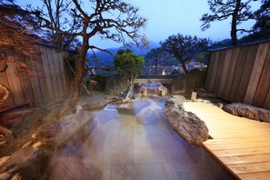 A hot spring bath area with wooden walkways and a view of a mountainous landscape. - Wakamatsu HakoneYugawara (Yugawara)