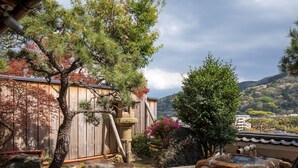 A traditional Japanese garden with a wooden structure, a clear water feature, and surrounding vegetation. - Wakamatsu HakoneYugawara (Yugawara)
