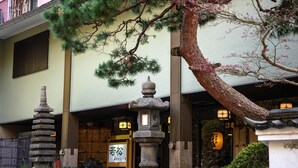 A traditional Japanese building with a wooden gate, stone lanterns, and a bonsai tree. - Wakamatsu HakoneYugawara (Yugawara)