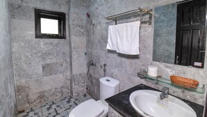 A bathroom with a toilet, shower, sink, and a mirror. - Hoi An Bali Homestay (Da Nang)