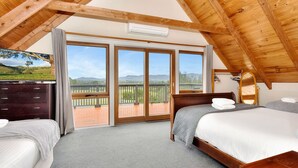 A bedroom with two beds, a wooden ceiling, a balcony with a view, and a dresser. - Silver Springs Cottage Hunter Valley Retreat (Rothbury)