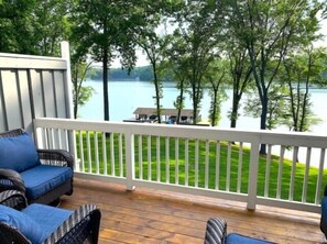 A wooden deck with wicker furniture overlooking a lake and trees. - Shorely Heaven:  WiFi, Disney+, Amazon Prime, YouTubeTV, (2) Kayaks Wide Water Lake Views (Moneta)