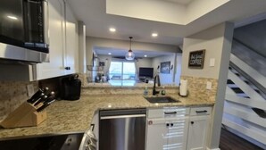 A modern kitchen with granite countertops, stainless steel appliances, and a view to the living area. - Shorely Heaven:  WiFi, Disney+, Amazon Prime, YouTubeTV, (2) Kayaks Wide Water Lake Views (Moneta)