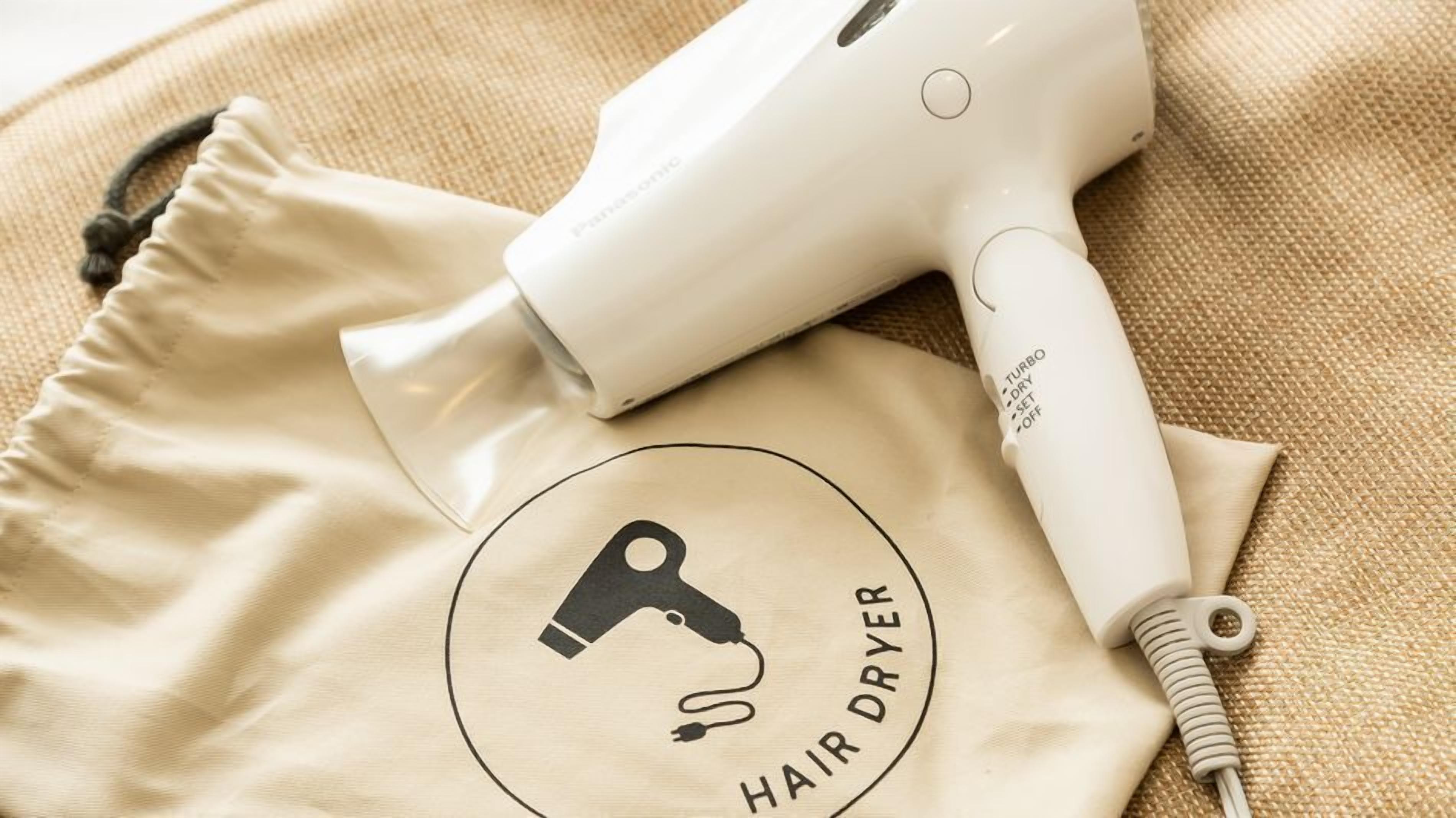 A hair dryer and a beige cloth with a logo and text.